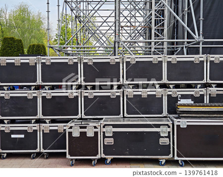 Scaffolding and flight cases on wheels at an outdoor stage setup Scaffolding and flight cases on wheels at an outdoor stage setup 139761418