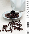 Roasted coffee beans in a plain white package and served on a plate. 139761885