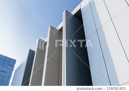 Modern white building facade featuring vertical geometric details and minimalist design Modern white building facade featuring vertical geometric details and minimalist design 139761955