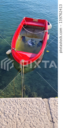 Small Red Rowboat Filled with Water Small Red Rowboat Filled with Water 139762413