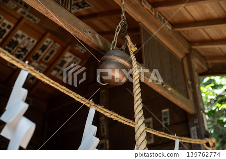 A traditional Japanese scene of bells and sacred ropes hanging at a shrine. A traditional Japanese scene of bells and sacred ropes hanging at a shrine. 139762774