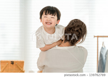 一位笑容燦爛的男嬰被母親抱在家中（家庭，父母和孩子） 139762789