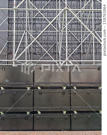 Stacked professional speaker cabinets on wheels before a large LED stage wall Stacked professional speaker cabinets on wheels before a large LED stage wall 139763064