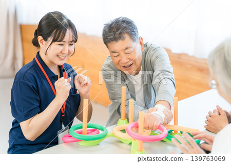 正在接受復健治療的老年男性、照護人員和女性職能治療師 正在接受復健治療的老年男性、照護人員和女性職能治療師 139763069