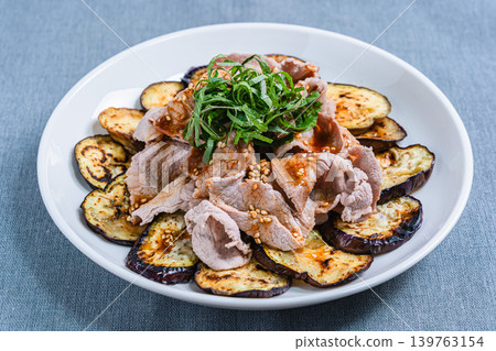 Grilled eggplant topped with pork shabu-shabu placed on the table Grilled eggplant topped with pork shabu-shabu placed on the table 139763154