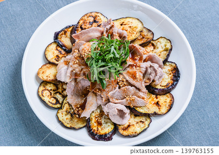 Grilled eggplant topped with pork shabu-shabu placed on the table Grilled eggplant topped with pork shabu-shabu placed on the table 139763155