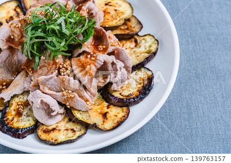 Grilled eggplant topped with pork shabu-shabu placed on the table Grilled eggplant topped with pork shabu-shabu placed on the table 139763157