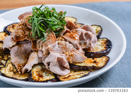 Grilled eggplant topped with pork shabu-shabu placed on the table Grilled eggplant topped with pork shabu-shabu placed on the table 139763163