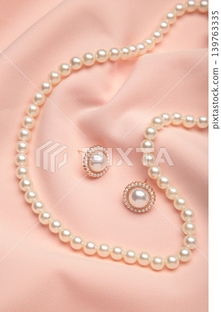 Beautiful pearl bracelet, earring, and necklace on pink texture background. Vertical photo Beautiful pearl bracelet, earring, and necklace on pink texture background. Vertical photo 139763335