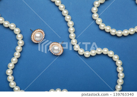 Beautiful pearl bracelet, earring, and necklace on dark blue background Beautiful pearl bracelet, earring, and necklace on dark blue background 139763340