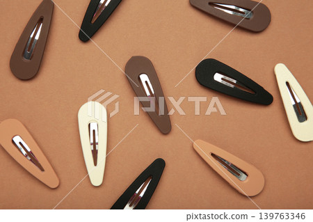 Colored pastel hair clips on brown background. Colored pastel hair clips on brown background. 139763346