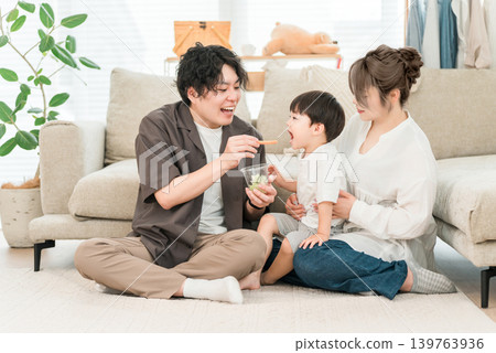 A boy eats vegetable sticks as a snack or light meal with his parents and family. A boy eats vegetable sticks as a snack or light meal with his parents and family. 139763936