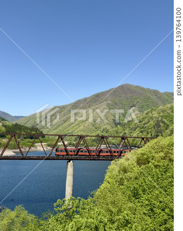 The AIZU Mountain Express travels through the lush greenery of Igarashi Lake. 139764100