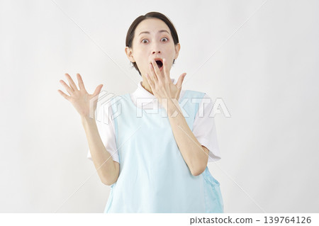 Surprised female caregiver against a white background Surprised female caregiver against a white background 139764126
