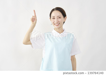 一位女護理員在白色背景前向上指著。 139764140