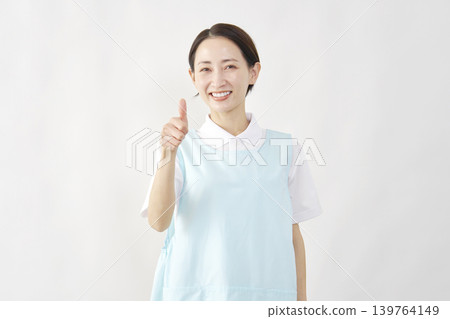 一位女護理員在白色背景前豎起大拇指。 139764149