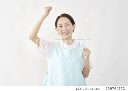 一位女護理員在白色背景前擺出勝利姿勢。 139764152