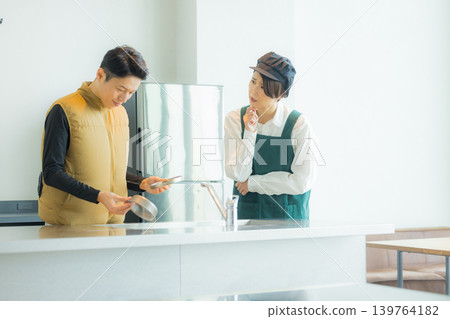 A male craftsman wearing an air-conditioned suit having a meeting while looking at documents A male craftsman wearing an air-conditioned suit having a meeting while looking at documents 139764182