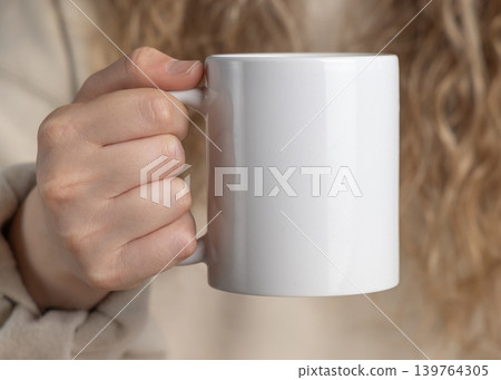 Blank white 11 oz coffee mug mockup in hand of young woman closeup, ceramic cup template Blank white 11 oz coffee mug mockup in hand of young woman closeup, ceramic cup template 139764305