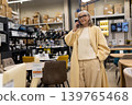 Mature woman talking on phone while shopping for furniture in a store 139765468