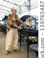 Senior woman examining barbecue grill while shopping in a hardware store 139765487