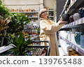 Senior woman shopping for new flowerpots in a retail garden center 139765488