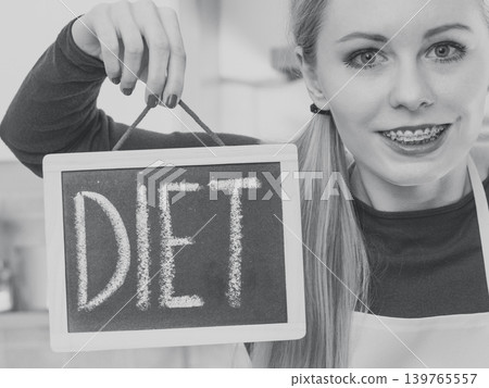Happy woman holding board with diet sign Happy woman holding board with diet sign 139765557