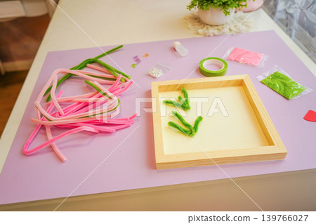 Twisting bright wires into meadow flowers. Play boosts hand strength and creative thought. Twisting bright wires into meadow flowers. Play boosts hand strength and creative thought. 139766027