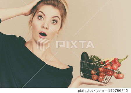Woman with vegetables, shocked face expression Woman with vegetables, shocked face expression 139766745