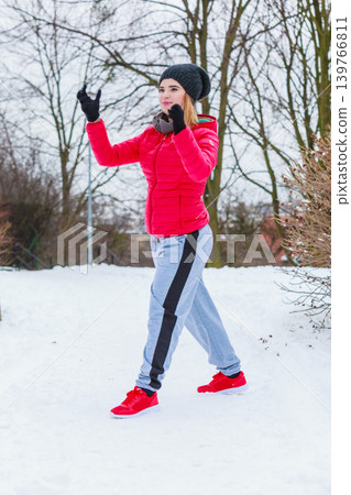 Woman wearing sportswear exercising outside during winter Woman wearing sportswear exercising outside during winter 139766811