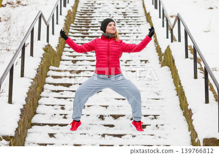 Woman wearing sportswear exercising outside during winter Woman wearing sportswear exercising outside during winter 139766812