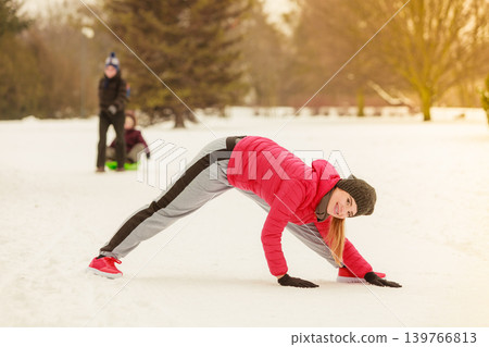 Woman wearing sportswear exercising outside during winter Woman wearing sportswear exercising outside during winter 139766813