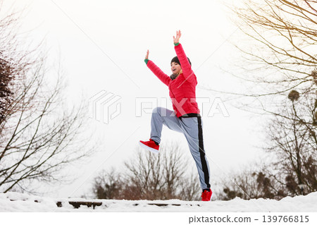 Woman wearing sportswear exercising outside during winter Woman wearing sportswear exercising outside during winter 139766815