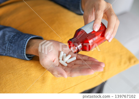 Close-up person pouring medicine from bottles into the hand. Close-up person pouring medicine from bottles into the hand. 139767102