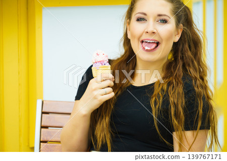 Young woman eating ice cream 139767171