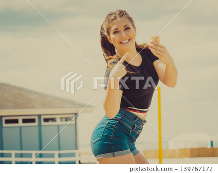 Young woman eating ice cream 139767172