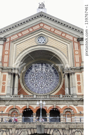 the Great Hall facade of Alexandra Palace is an architectural masterpiece composed of pale cream and rich terracotta brickwork. Its defining feature is a monumental, deep-set semicircular arch framing the Great Hall facade of Alexandra Palace is an architectural masterpiece composed of pale cream and rich terracotta brickwork. Its defining feature is a monumental, deep-set semicircular arch framing 139767461