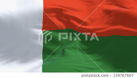 Malagasy flag of Madagascar waving in wind on clear blue sky. 3D render Malagasy flag of Madagascar waving in wind on clear blue sky. 3D render 139767607