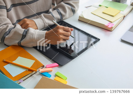 College student studying for exams with digital tablet and notebooks. College student studying for exams with digital tablet and notebooks. 139767666