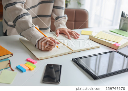 Professional freelancer analyzing and taking notes during remote work session. Professional freelancer analyzing and taking notes during remote work session. 139767678