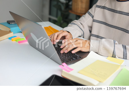 Creative professional working from home brainstorming ideas with laptop and stationery. 139767694