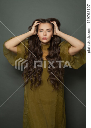 Glorious woman hair. Beautiful model with long curly hairstyle posing Glorious woman hair. Beautiful model with long curly hairstyle posing 139768107