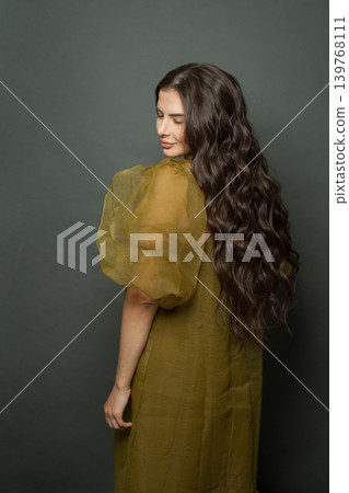 Nice woman hair. Beautiful model with long curly hairstyle posing 139768111