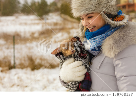Woman hug warming her little dog in winter Woman hug warming her little dog in winter 139768157