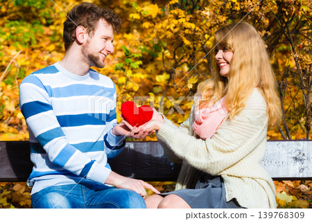 Girl show feelings to man in autumnal park. 139768309