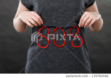 Woman holding red SOS sign, she need help Woman holding red SOS sign, she need help 139768486