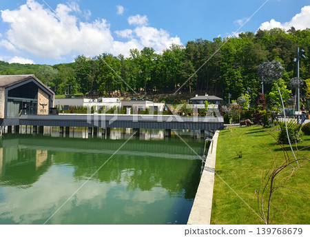 Modern recreation complex on the lakeshore with a green lawn, stylish bridge and terrace Modern recreation complex on the lakeshore with a green lawn, stylish bridge and terrace 139768679