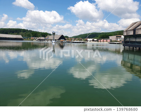 Panoramic view of a modern resort complex near a large lake. Picturesque reflection of white clouds in the water 139768680