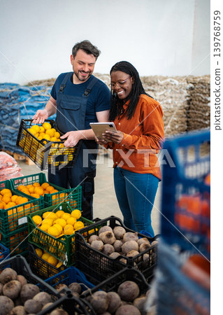 Farmers Market Workers Using Tablet for Inventory Management 139768759