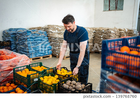 Male worker handling fresh fruit vegetables in warehouse 139768760